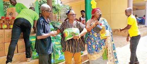 Nana Osei Agyemang Prempeh Dwamena (middle), Hweakwaehene, being assisted by Nana Asantewaa Nkyema (right), Queenmother of Hweakwae, to present the items to one of beneficiaries