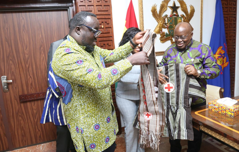 President Akufo-Addo (right) being decorated with Red Cross paraphernalia by Dr Edward Donkor, acting President, Ghana Red Cross Society, at the Jubilee House. With them are members of the society. Picture: SAMUEL TEI ADANO