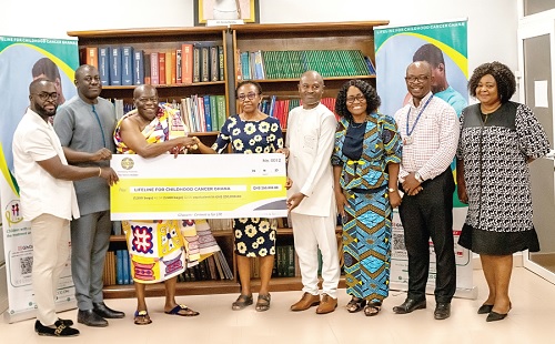 Nana Prah Agyensaim VI (3rd from left) leads the Ghacem team to hand over the dummy presentation to the Korle Bu team, led by Prof. Christabel Laryea, Head of Department, Child Health, while Prof. Lorna Renner (3rd Right) and others look on