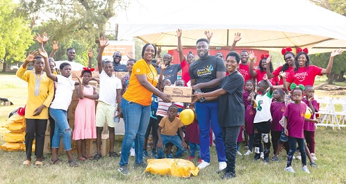 Majorie Quansah presenting a gift to one of the children