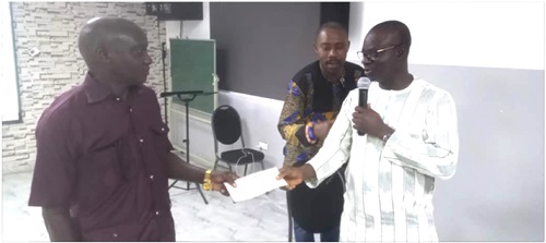 Osmani Aludiba Ayuba (right), NEDCO MD, presenting a cheque to Gilbert Azure, Finance Officer of the Gbewaa College of Education