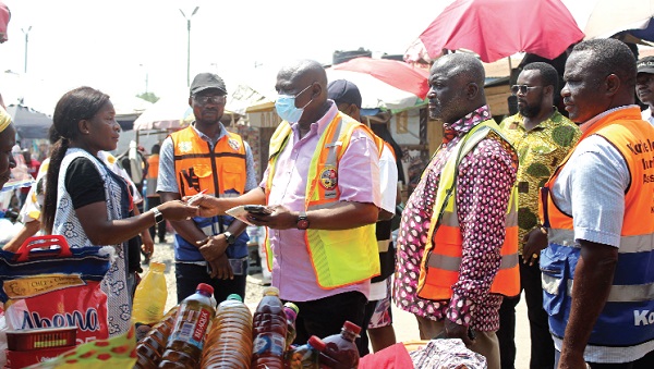 Emmanuel Baisie (3rd from left), Coordinating Director, Korle Klottey Municipal Assembly, inspecting tickets of some vendors while James Samuel Nii Adjei Tawiah (4th from right), Municipal Chief Executive, Korle Klottey Municipal Assembly, looks on. Picture: ERNEST KODZI
