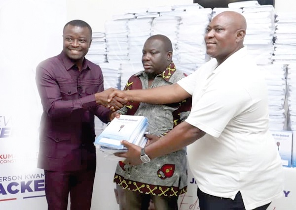 Jefferson Sackey (left), the Deputy Communications Director, Office of the President, presenting some books to Robert Kwame Dadzie Okine (right), the NPP Chairman of Ablekuma Central. With them is Emmanuel Tetteh Okine, Electoral Area Coordinator, Abossey Okine 