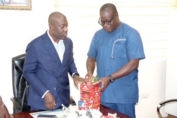 Kojo Oppong Nkrumah (left), Minister of Information, presenting some boxes of chocolates to Theophilus Yartey, acting Editor, Graphic. Picture: Elvis Nii Noi Dowuona 