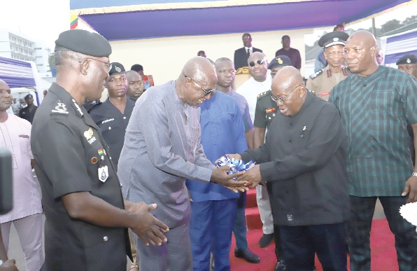 • President Akufo-Addo (right) handing over keys to the vehicles and the motorbikes to Ambrose Dery (2nd from left), Minister for the Interior, with Dr George Akuffo Dampare (left), the IGP, looking on. Pictures: SAMUEL TEI ADANO