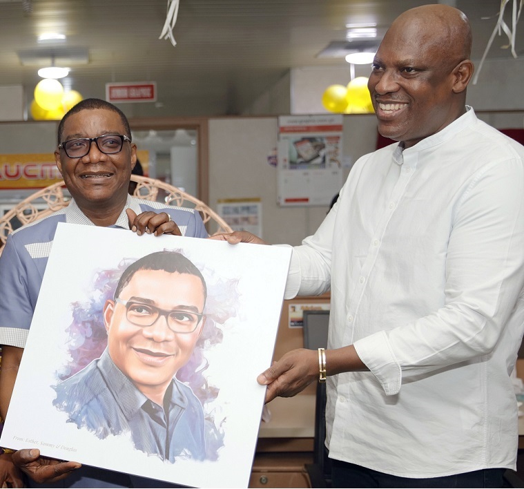 Ato Afful (right), MD, GCGL, presenting an artwork to Kobby Asmah, Editor, Graphic, last Friday during a send-off party organised for him