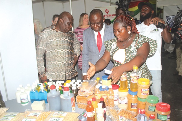 • Mary Badu (right),  Head of Department of Agribusiness, Damongo Agric College, explaining how the product is made to  Yaw Frimpong Addo (2nd from right), Deputy Minister of Food and Agriculture, during the exhibition. Picture: ESTHER ADJORKOR ADJEI