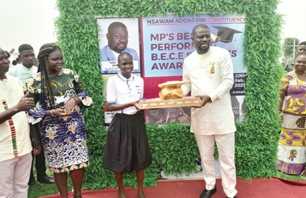 Frank Annoh-Dompreh (right), MP for Nsawam-Adoagyiri, presenting a laptop, scientific calculator, dictionary and undisclosed amount of money to Nancy Aloba Bonsu, an awardee.