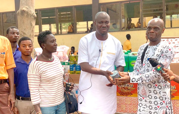 •Thomas Hughes Amissah (2nd from right), the NDC parliamentary aspirant, presenting a tin of sardine to Abraham Annang Yemoson (right), Headmaster of the Cape Coast School for the Deaf and Blind