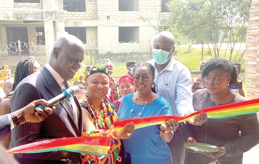 Kwesi Anin Yeboah (left), the Chief Justice, being assisted by Ursula Owusu-Ekuful (3rd from left),MP for Ablekuma West, and Nii Adote Odaawulu I of  the Sempe Traditional Council, to cut the tape to inaugurate the new court building