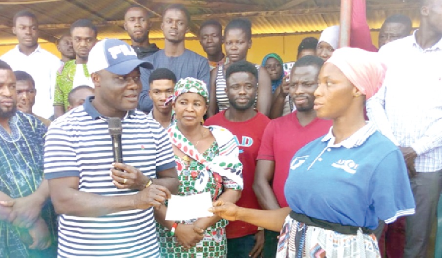 Ahmed Ibrahim (left), MP for Banda, presenting a cheque to one of the beneficiaries