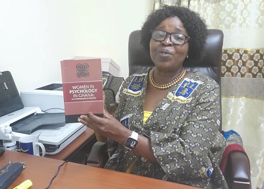 Professor Charity Sylvia Akotia holding a copy of the book she co-edited with Dr Emmanuel Nii-Boye Quarshie 