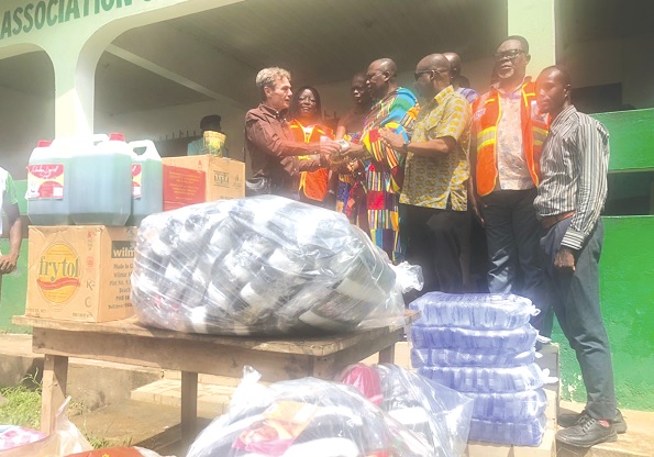 Nana Agyeman (4th from right) receiving the items on behalf of the people from Marc Genot (left), Chief Executive of SIPH, mother company of GREL