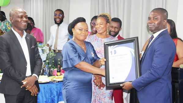 Janet Okantu (2nd from left), the Overall Best and longest-serving worker, receiving a citation from Dr Richard Odor (right), Chief Executive Officer, Top-Up Pharmacy, at an award and dinner ceremony in Tema. Picture: SAMUEL TEI ADANO