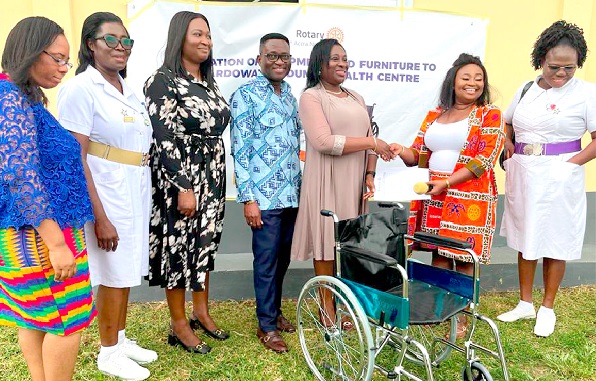 Rita Donkubari (2nd from right), President of the club, presenting one of the wheelchairs to Dr Charity Sarpong, Greater Accra Regional Director of Health Service, while Ebenezer Asiamah (4th from left), District Director of Health Service, and other officials look on