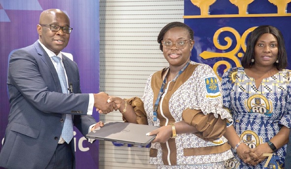 Kwamina Asomaning (left), Stanbic Bank’s Chief Executive, presenting one of the laptops to Prof. Nana Aba Appiah Amfo (middle), Vice-Chancellor of the University of Ghana