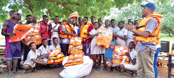 Rev. Isaac Owusu (arrowed) handing over the life jackets to the school. Looking on are Alhaji Kassim Seidu Baba, the Regional General Secretary for GNAT, some students and teachers
