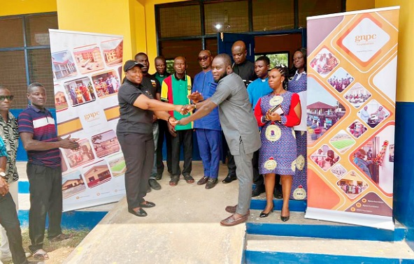 Lubaabat Habib-Jawulaa (left), Head of Environment and Social Amenities, GNPC, handing over the keys to the buildings to Nana Aduyaw Sumpremo, a representative of the Chief of Ayakomaso 