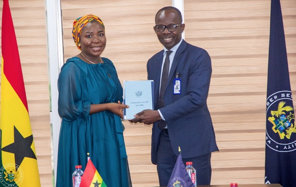 Dr Albert Antwi-Boasiako (right), Director-General, Cyber Security Authority, presenting a copy of the Cybersecurity Act to Fatimatu Abubakar, a deputy Minister of Information