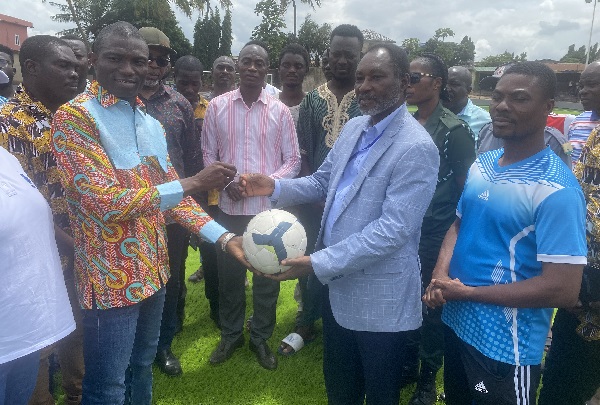 Alexander Daniel Nii Noi Adumoah, MCE of the Adentan Municipality (2nd right), receiving the key to the artificial turf from Dr Dominic Kwesi Eduah, Executive Director of GNPC Foundation 