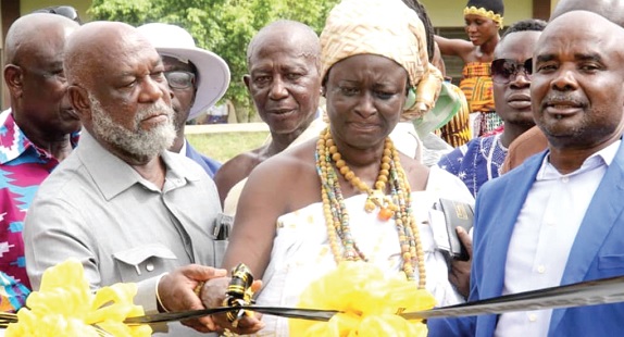 Nana Anmoa Framoh, Bankahemaa, being assisted by Prof. Kwame Karikari (left) to cut the tape for the construction of the sports complex. With them is Christopher Appiah Mensah (right), Headmaster of the school. Pictures: EMMANUEL BAAH