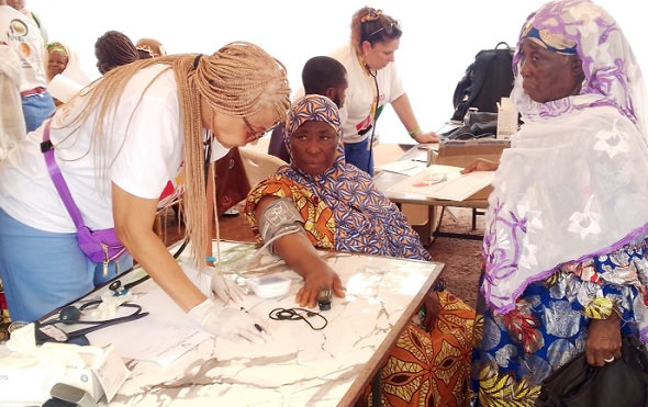 A health worker (left) attending to some of the beneficiaries