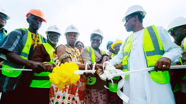 Kwabena Okyere Darko-Mensah (right), the Western Regional Minister, being assisted by Kojo Acquah (2nd from left), the MCE of Effia-Kwesimintim Municipal Assembly, Nana Asante Kojo (3rd from left), Chief of Asakae, and other dignitaries to cut the tape to commission the waste treatment plant (below)