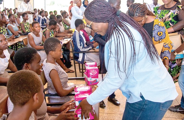 Joyce Bawah Mogtari (right), Special Aide to former President John Mahama, presenting the pads to some SHS students in Tamale  