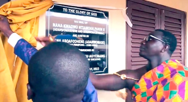 Nana Ntiamoah Panin II,  Adanwomasehene, unveiling  the plaque to inaugurate the three-unit classroom block. INSET: The classroom block
