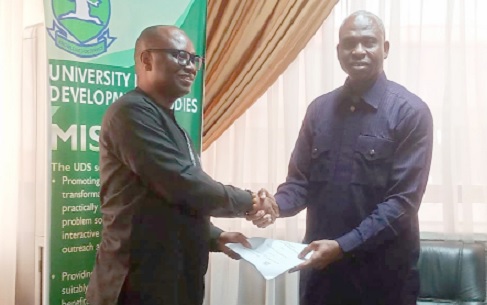John Nkaw (left), Country Director of ActionAid Ghana, presenting the MoU documents to Prof. Seidu Al-hassan, Vice Chancellor of UDS