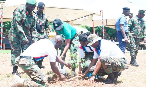 Vice Admiral Seth Amoama (arrowed) being assisted by some military personnel to plant a tree to mark the day.  Picture: DELLA RUSSEL OCLOO