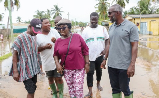 Dzifa Gomashie (middle), MP for Ketu South, and some residents touring some flooded areas