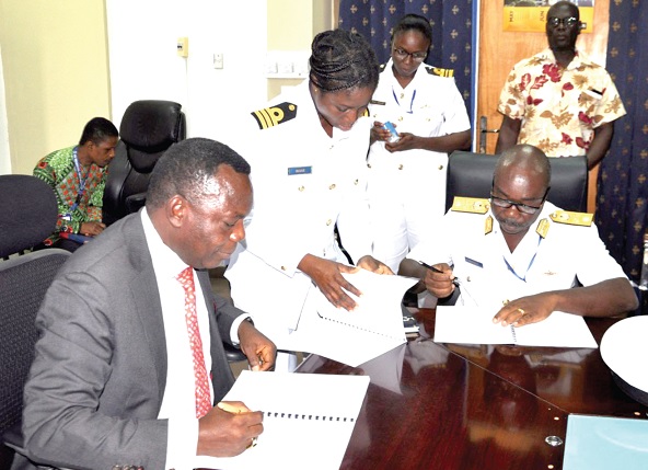 Commodore Modey (right) signing the MoU on behalf of the Navy while  Prof. Honyenuga (left) appends his signature for the Ho Technical University 