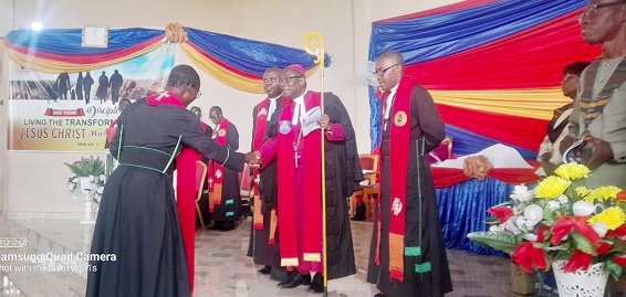 Rt Rev. Alfred Appiah Andam (with staff in hand), Bishop of the Wenchi Methodist Church Ghana, congratulating the Very Rev. Kennedy Peter Ansah-Eshun, Superintendent Minister of the Kintampo North Circuit, after the inauguration