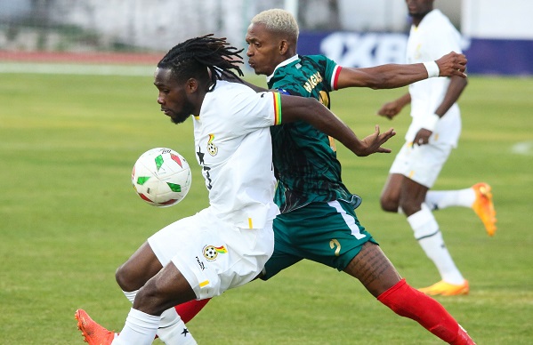Joseph Paintsil shields the ball away from Charles Andriamahitsinoro