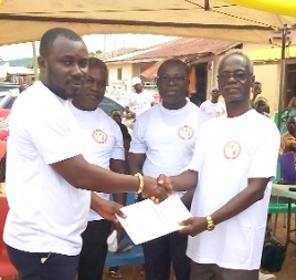 John Obuaba (left), the Executive Director of Celdar Foundation, presenting a certificate of registration to Asafoatse Okumani Gyau, the chairman of the foundation