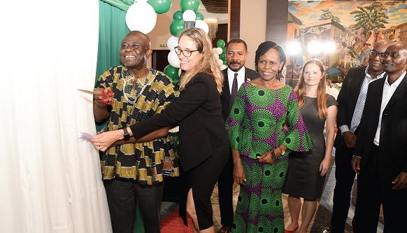 Yaw Frimpong Addo (left), Deputy Minister of Food and Agriculture, being assisted by Vanessa Adams, Vice-President,  AGRA, to cut the ribbon to launch the Strategy Plan. With them are Juliette Lampoh-Agroh (3rd from left), Country Manager, Ghana AGRA, and some officials. Picture: EBOW HANSON