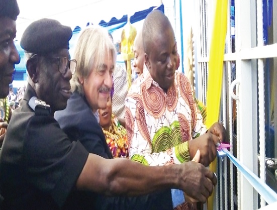 Simon Kweku Tetteh (right), the Lower Manya Krobo MCE, being assisted by Roger Aboujaoude(middle), the General Manager of Maleka Farms and DCOP Emmanuel Twumasi-Ankrah (left), the Eastern Regional Police Commander, to inaugurate the facility