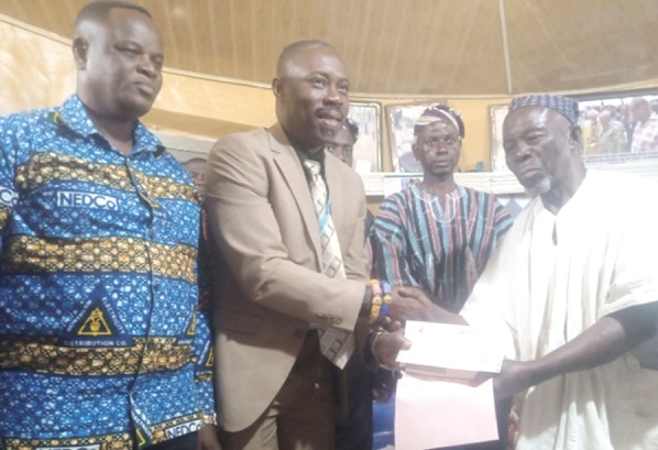 Mbadugu Fuseini Abukari (right) receiving the cheque on behalf of the Ya-Na from Maxwell Kotoka, Corporate Affairs Manager of NEDCo
