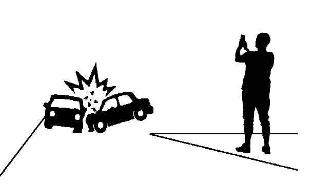 An accident scene showing a member of the public using his mobile phone to video instead of providing help.