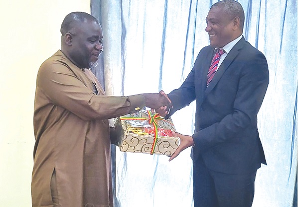 Kwaku Ofori Asiamah (left), Transport Minister, presenting a gift to Adelino Afonso Fernandes Rosa Cardoso (right) of São Tomé and Príncipe