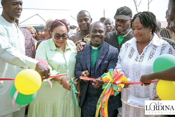 Lordina Dramani Mahama (2nd from left) being assisted to cut the tape to inaugurate the water systems 