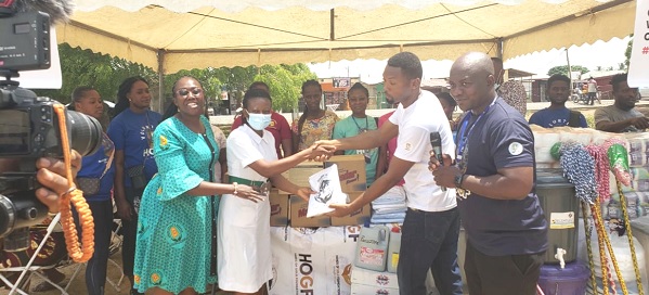 • Rex Kumodji (2nd from right), Administrator of Hands of Gold Foundation, presenting the items to Akosua Adjei (2nd from left), Finance Director of HOGF