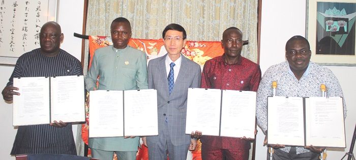 Hisanobu Mochizuki (middle) with Francis Asong (right), Dr Maurice Jonas Woode (2nd from right), Philip Kwabena Boahen (2nd from left) and Timothy Fordjour Kanyebui (left) displaying the documents of the contracts. Picture: ESTHER ADJORKOR ADJEI  