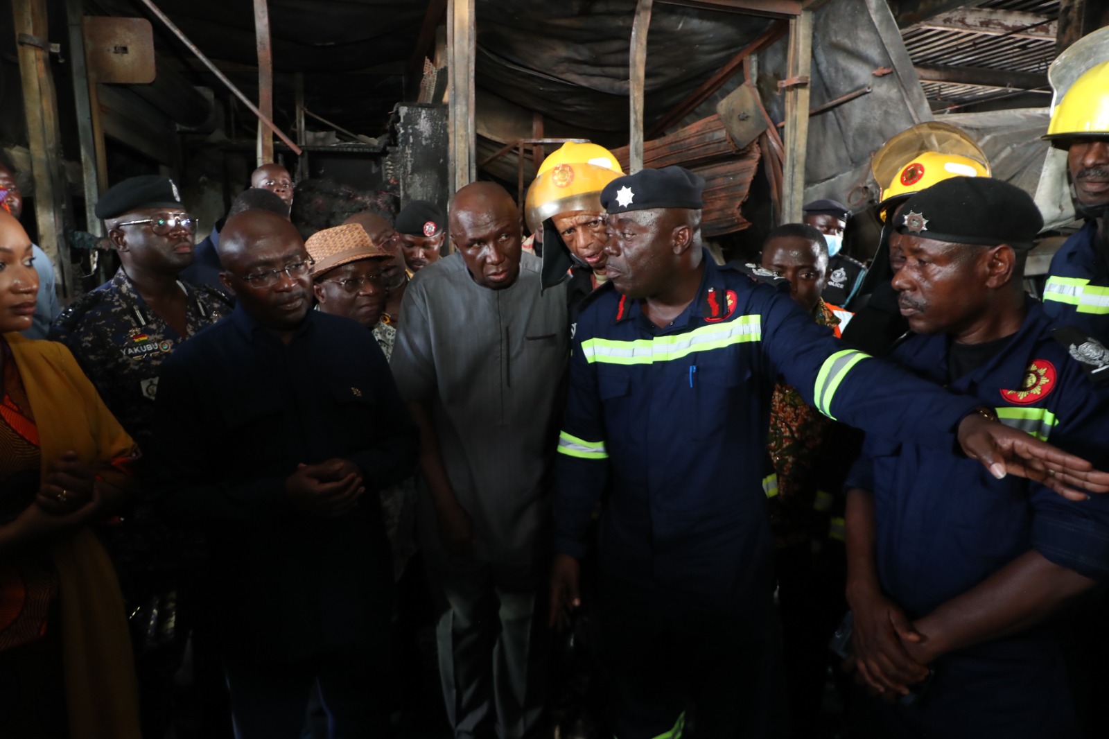 Vice President Bawumia being briefed by fire officers when he visited the damaged area of the Kejetia market on Monday