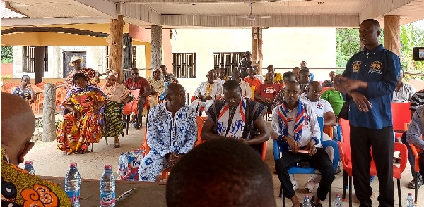 Akwasi Afrifa-Mensa (standing), Member of Parliament for Amasaman, speaking to some community members during the engagement