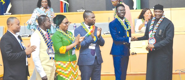 • President Adama Barrow (right), President of The Gambia, presenting the Overall Best Candidate award to Alex Opoku Manu, winner, International Excellence Awards, WASSCE for School Candidates, 2022, while Wendy E. Addy-Lamptey (2nd from left), HNO of WAEC; Dr Eric Nkansah (3rd from right), Director-General of the GES, and others applaud