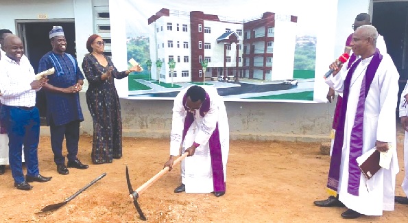 •Rev. John Shadrack Donkoh (with axe), the Bishop of the Evangelical Lutheran Church of Ghana, breaking the ground to start the project while some guests look on