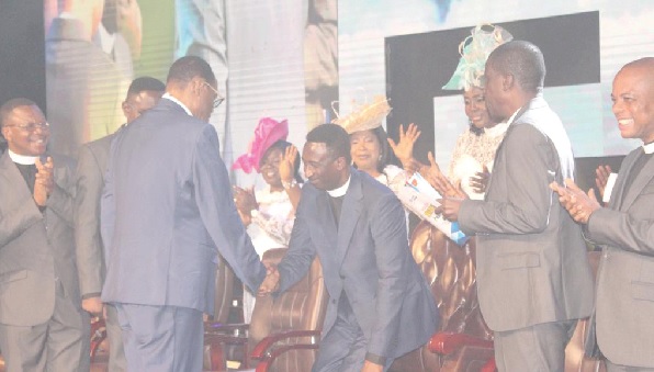 • Apostle George Yeboah (back to camera), immediate past Chairman of the CACI, congratulating Apostle Samuel Amponsah Frimpong, the new Chairman, after the induction