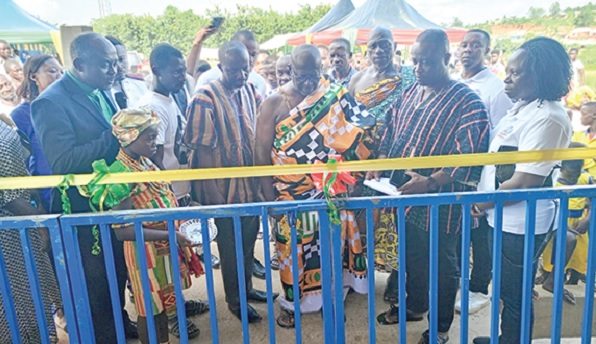 • The front view of the primary school block. INSET: Nana Karikari Appau Frimpong  (in cloth), the Asenehene, being assisted by Kwame Danso (in smock) and George Somuah (3rd from left) to cut the tape to inaugurate the renovated classroom blocks